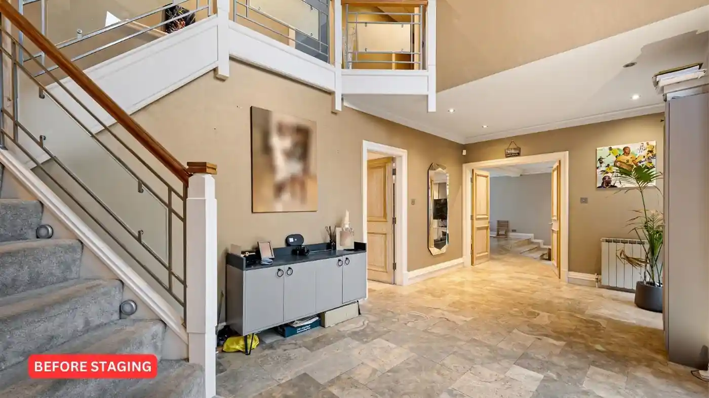 A hallway in a home, not staged for sale with a staircase.