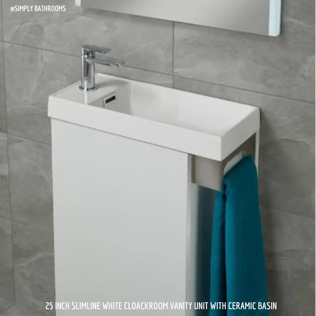 A modern white slimline bathroom vanity unit with a ceramic basin, mounted against a grey tiled wall. A blue towel hangs on a rail attached to the vanity, perfect for designing small spaces. Text: "25 inch slimline white cloakroom vanity unit with ceramic basin".