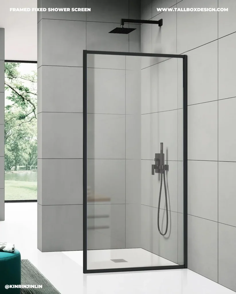 Modern bathroom with a walk-in shower featuring a black-framed, fixed shower screen and a rainfall showerhead. Large gray tiles cover the walls, and a window offers a view of greenery outside.